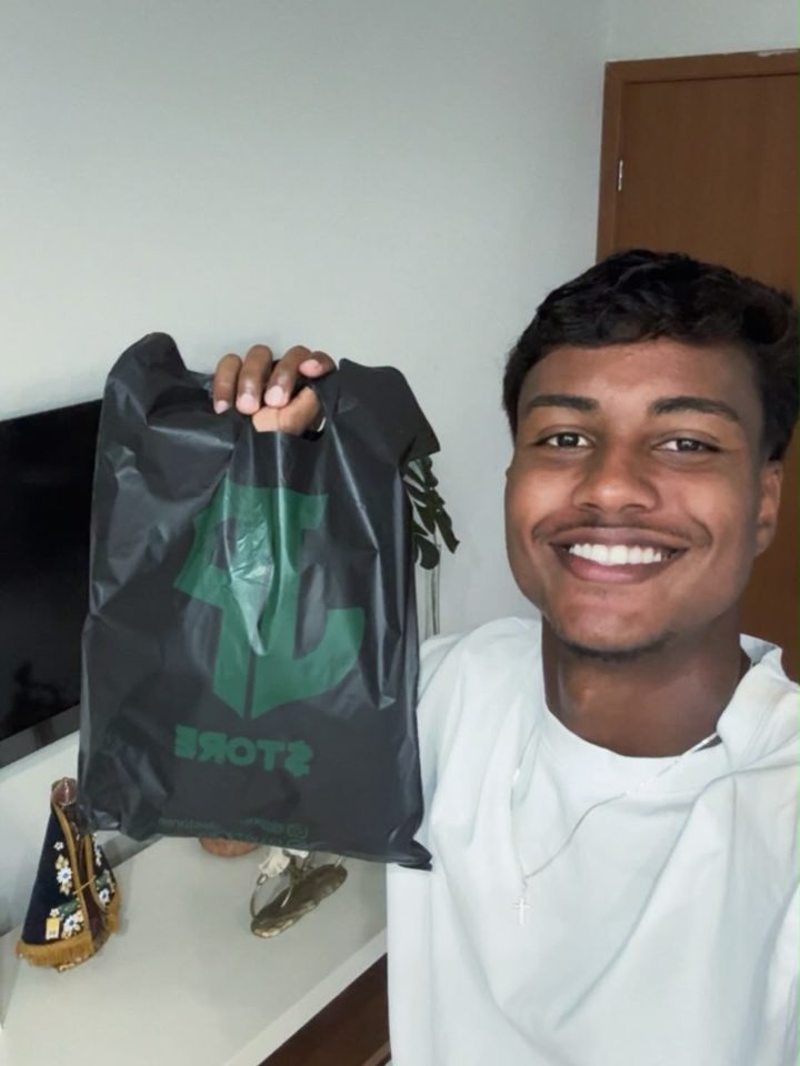Atleta da base do Cruzeiro com a sacola da JP Store